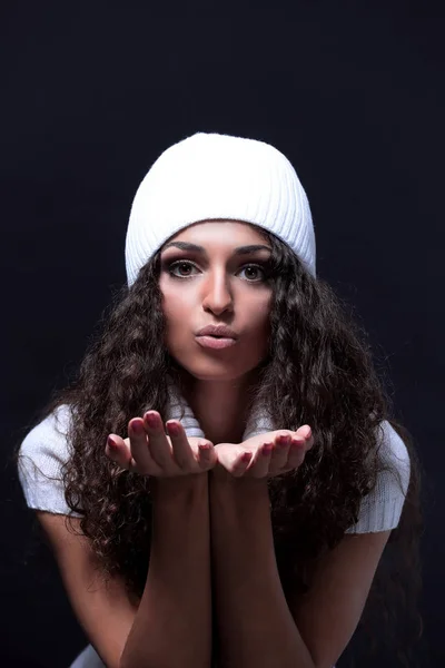 Portrait of a girl in a white knitted hat sends a kiss — Stock Photo, Image