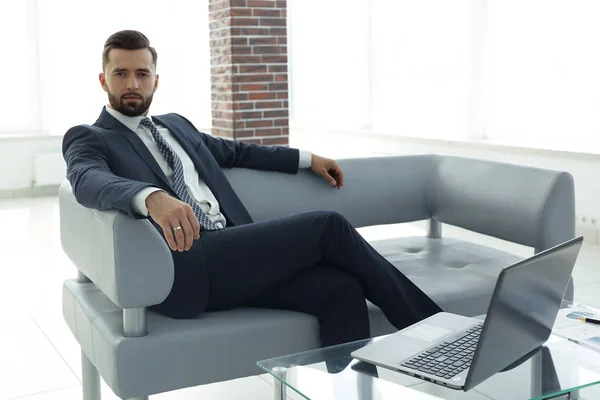 Hombre de negocios sentado en el vestíbulo de una oficina moderna . — Foto de Stock