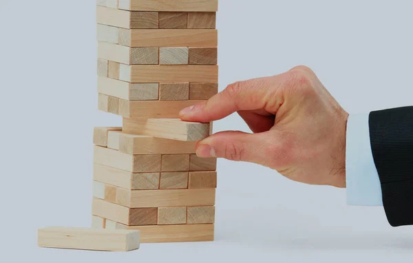 Башня из деревянных блоков и человек руки взять один блок. — стоковое фото