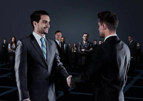 Retrato de jovens empresários. Aperto de mão na frente dos empresários — Fotografia de Stock