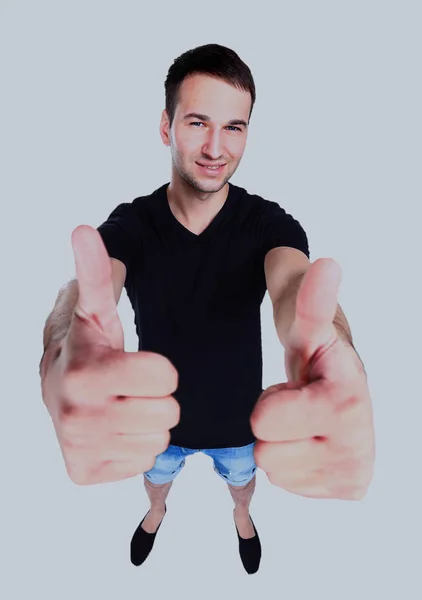 Glimlachend jongeman met duimen omhoog op een afgelegen witte achtergrond. — Stockfoto