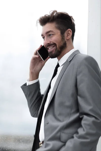 Un hombre de negocios con un traje inteligente hablando en un teléfono móvil — Foto de Stock