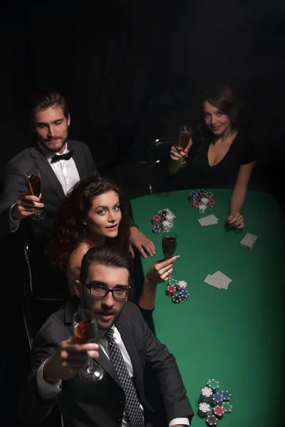 Groep van jonge rijke mensen speelt poker in het casino — Stockfoto