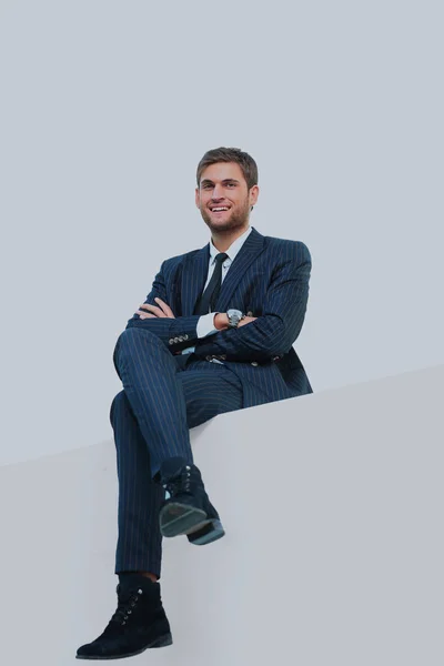 Przystojny młody biznes człowiek siedzi na szczycie biały. — Zdjęcie stockowe
