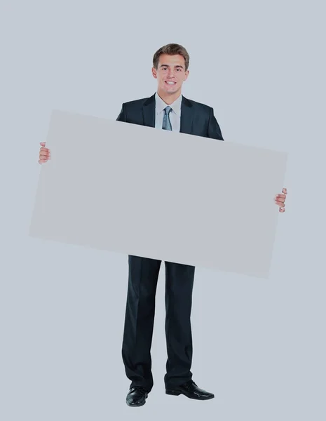 Feliz sorridente jovem homem de negócios mostrando placa em branco . — Fotografia de Stock