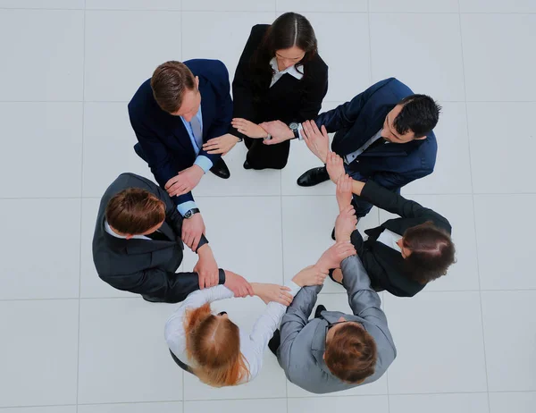 Вид сверху деловых людей, держащих руки вместе в кругу . — стоковое фото