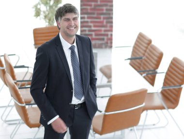 Bir boş toplantı odasında duran iş adamı