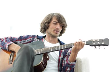 Yakışıklı adam evde kanepede gitar çalmaya