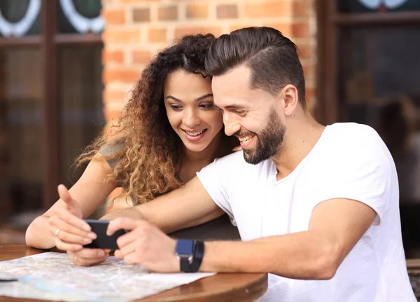 Feliz casal amoroso usando um smartphone sentado no terraço — Fotografia de Stock