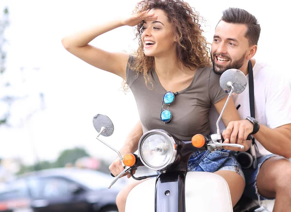 Beautiful young couple is smiling while riding a scooter — Stock Photo, Image