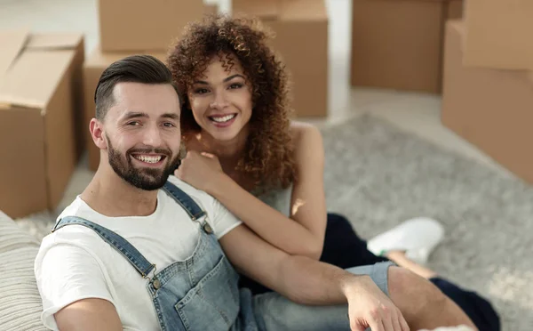 Jovem casal sentado no chão em um novo apartamento — Fotografia de Stock