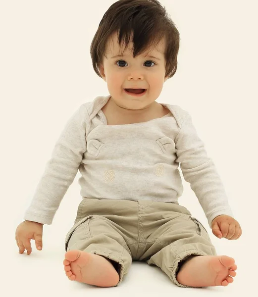 Bébé drôle assis sur le sol, isolé sur blanc — Photo