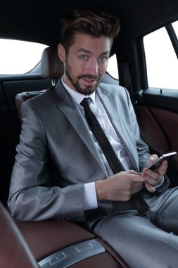 arabada oturan ve akıllı telefon mesajları okuma takım elbiseli adam