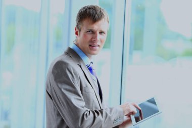 onun tablet üzerinde çalışan bir işadamı portresi.