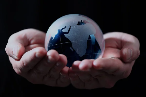 Mano sosteniendo globo translúcido con fondo azul . — Foto de Stock