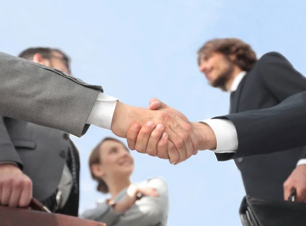 Equipe olhando para um parceiro handshake de negócios . — Fotografia de Stock