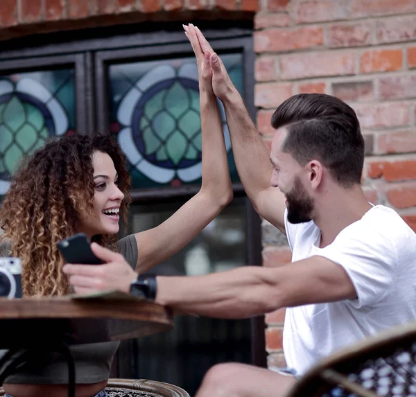 Porträt eines jungen Paares, das sich auf eine Caféterrasse setzt — Stockfoto