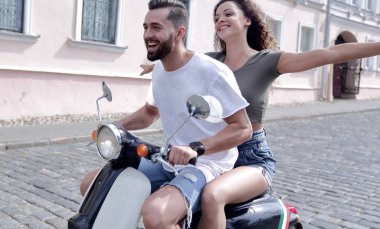 mutlu genç bir çift bir scooter üzerinde eğleniyor