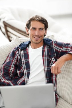 dizüstü bilgisayarda çalışan ve kameraya bakarak başarılı adam. Yukarıdan görüntülemek