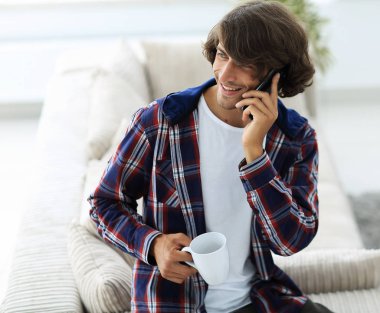 güzel bir fincan adamla bir dizüstü bilgisayar önünde oturur.