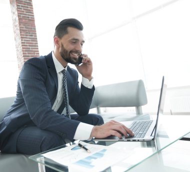 Smartphone üzerinde konuşmak ve metin dizüstü bilgisayarda yazarak işadamı