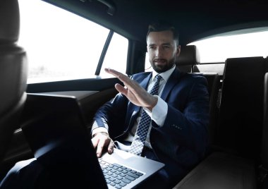 parmağını ileriye dönük ve arabanın arka koltukta oturan işadamı