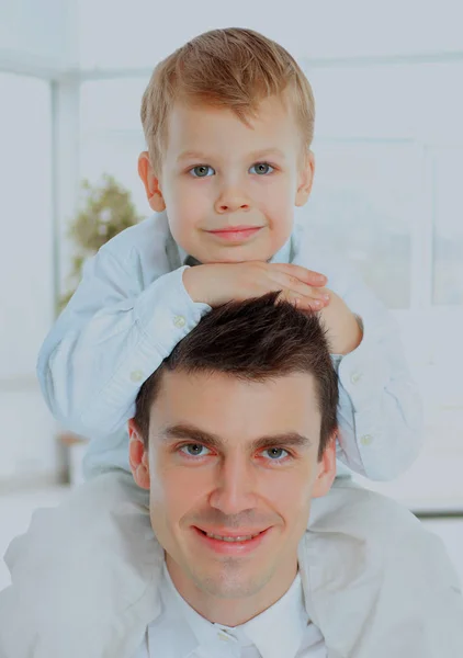 Portrait of the father holding his son on his shoulders. both look at the camera and smiling. — Stock Photo, Image