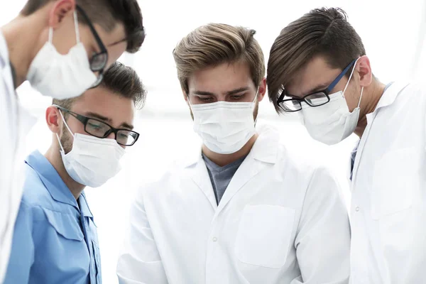 Primer plano. un equipo de médicos con máscaras protectoras . —  Fotos de Stock