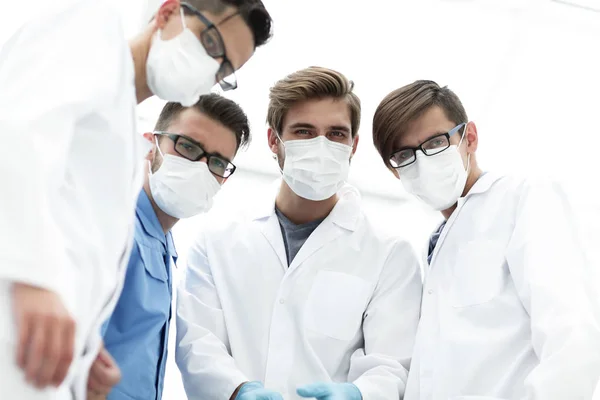 Närbild. ett team av läkare i skyddande maskerar. — Stockfoto