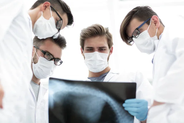 Чоловіки-лікарі уважно дивляться на рентгенівський знімок — стокове фото