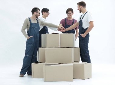 Neşeli Nakliyeciler beyaz arkasında izole kutularının yığında yaslanmış