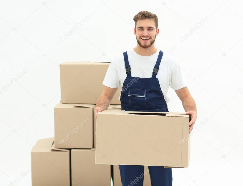 Young man carrying a box to the pile of boxes.