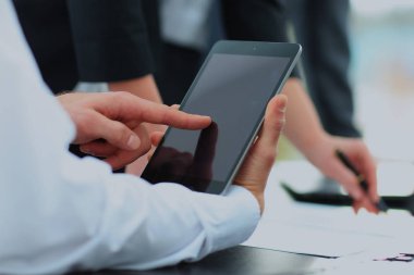 Toplantıda dijital tablet tutan işadamı.