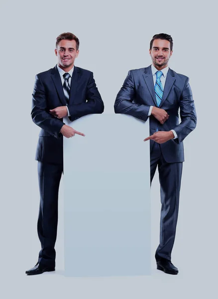 Dois homens de negócios sorridentes mostrando tabuleta em branco, isolado sobre fundo branco . — Fotografia de Stock