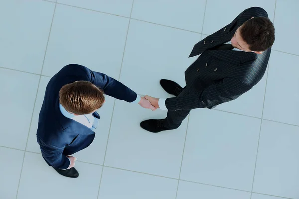 Top uitzicht van een twee zakenman schudden handen - Welkom bij het bedrijfsleven. — Stockfoto