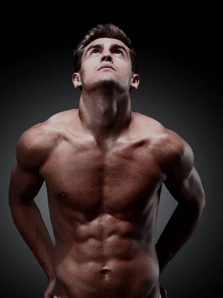 Retrato de joven hombre fuerte sobre fondo negro — Foto de Stock