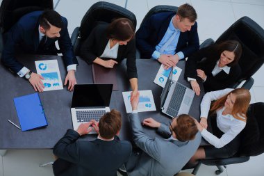 Toplantı bir ofiste bir masa etrafında.