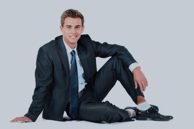 Beyaz bir arka plan üzerinde oturan iş adamı izole.