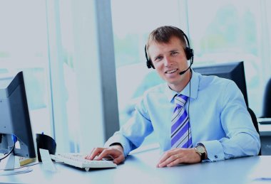 kulaklık kullanarak callcenter çalışma mutlu genç adam.