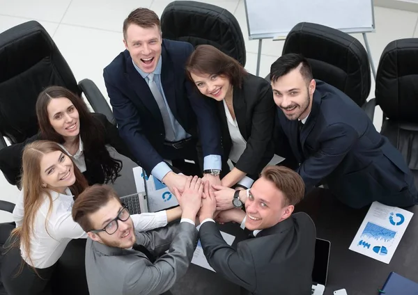 Zespół firmy z ręce splecione ze sobą na biurko — Zdjęcie stockowe