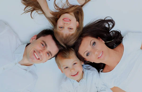 Family lying down on their bed at home. — Stock Photo, Image
