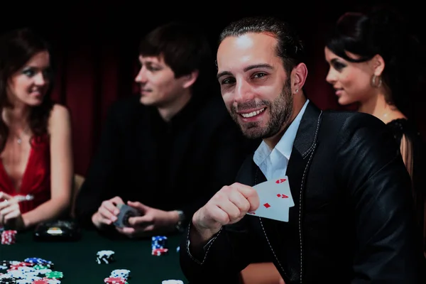 Pokerspelare som sitter runt ett bord på ett casino — Stockfoto