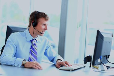 kulaklık kullanarak callcenter çalışma mutlu genç adam.