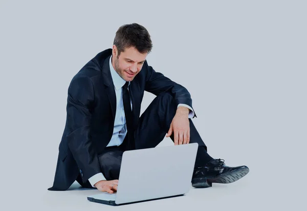 Gelukkig jonge business man aan het werk op een laptop, geïsoleerd op wit. — Stockfoto