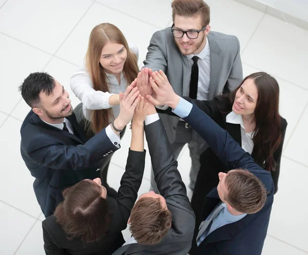 Primer plano. alegre equipo de negocios con las manos cruzadas juntas —  Fotos de Stock