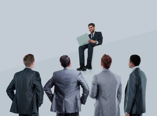 Bedrijfsconcept. zakenman aan een laptop te werken terwijl zijn collega's gadegeslagen. — Stockfoto