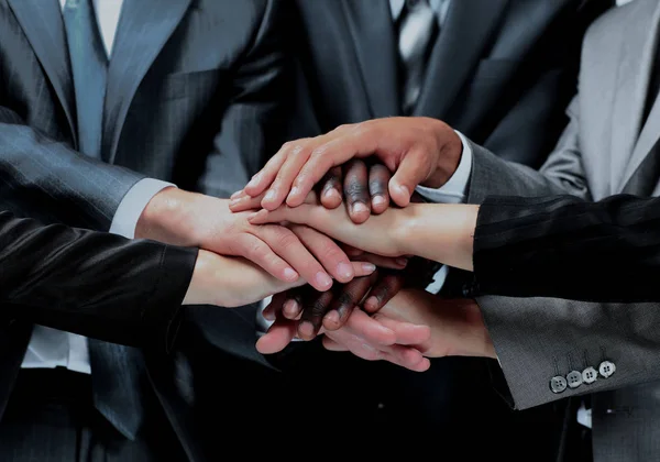 Gruppo eterogeneo di lavoratori con le mani unite sotto forma di lavoro di squadra . — Foto Stock