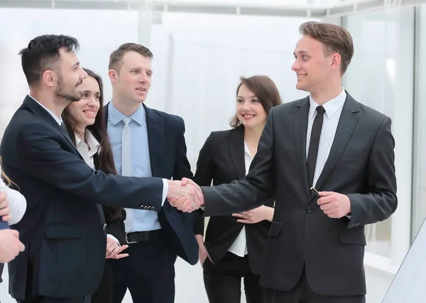 Equipe de negócios olha para os parceiros de negócios handshake — Fotografia de Stock