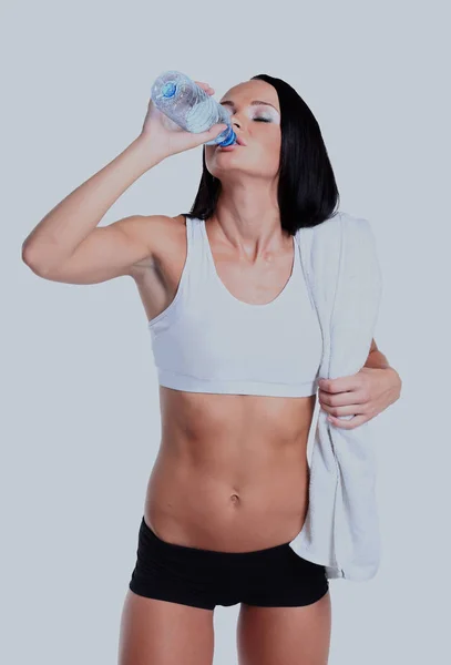 Happy smiling woman in sportswear drinking water, isolated over white background — Stock Photo, Image