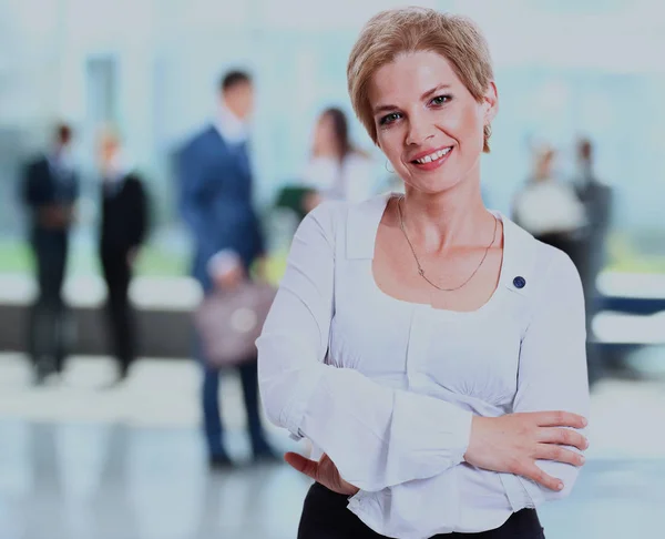 Giovane bella donna sorridente con il team in sfondo sfocato . — Foto Stock